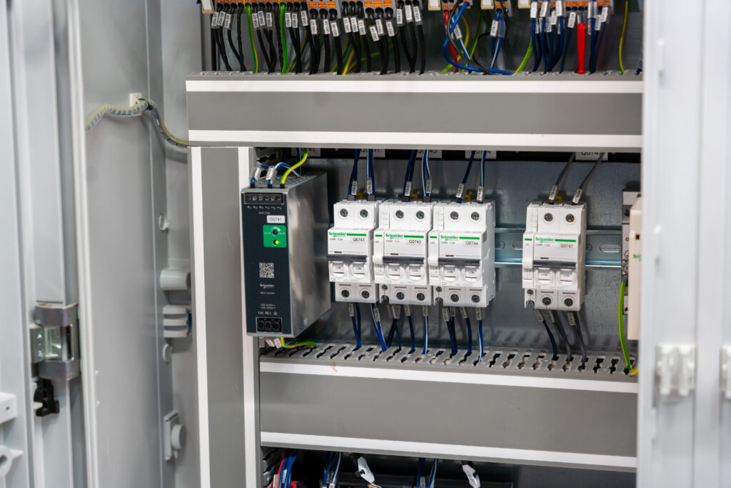Disjoncteurs et appareillages électriques de protection montés sur rail dans une armoire industrielle.