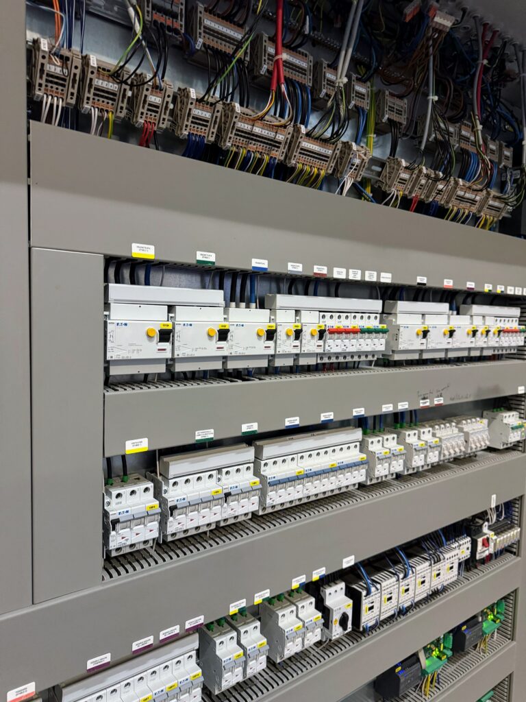 Ensemble de protections et d'appareillages électriques installés sur rails dans une armoire industrielle.