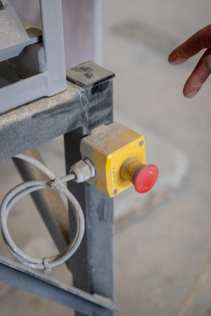 Bouton d'arrêt d'urgence d'un équipement industriel de manutention de céréales.