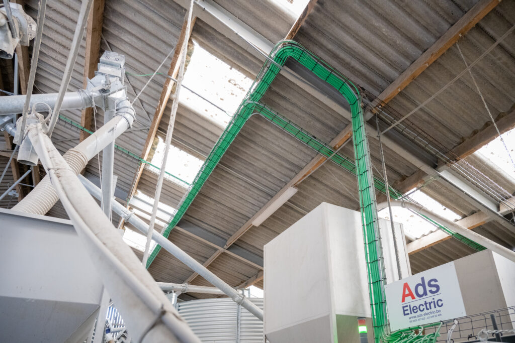 Réseaux de conduits techniques et équipements de manutention installés au-dessus des silos à céréales.