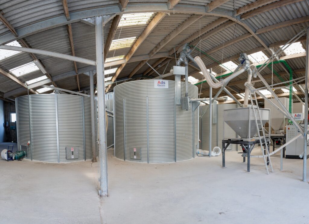 Réalisation industrielle ADS Automation : silo de stockage métallique dans un bâtiment industriel.