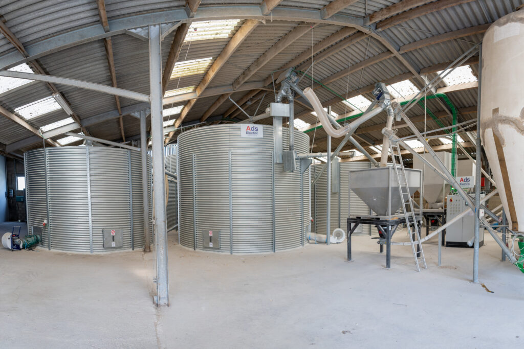Automatisation de silos à céréales à Dinant : installation de stockage avec silos métalliques et équipements de manutention.