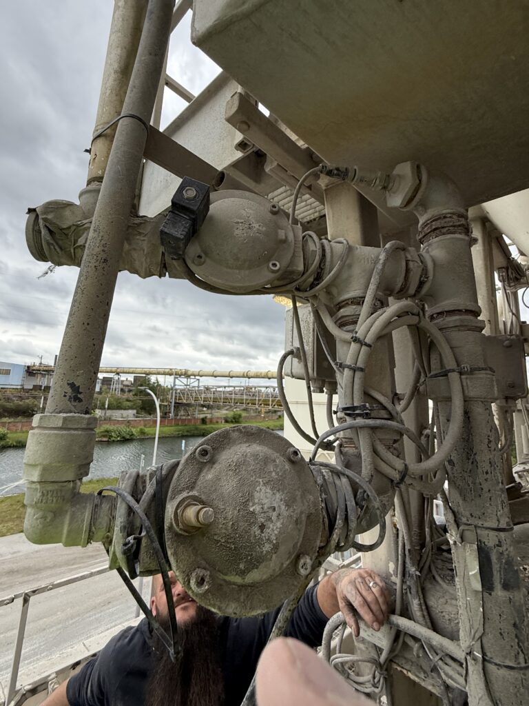 Ensemble d'électrovannes, raccords et tuyauteries du circuit de remplissage d'eau d'une centrale à béton.